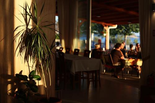 a table in a restaurant with people sitting at tables at Pension Augustino in Ražanac