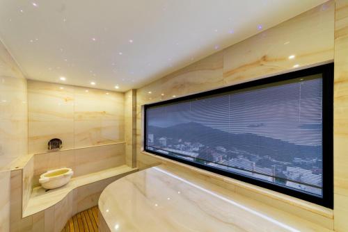 a large bathroom with a tub and a large window at Villa Panorama Kalkan Jilda Livya in Kalkan