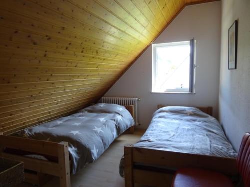 two beds in a room with a roof at Holiday Apartment Bombach in Kenzingen