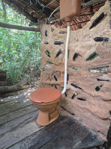 a bathroom with a toilet in a rock wall at Camping AlterArte Ecovila in Santarém
