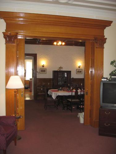 a dining room with a table and a television at Olde Judge Mansion B&B in Troy