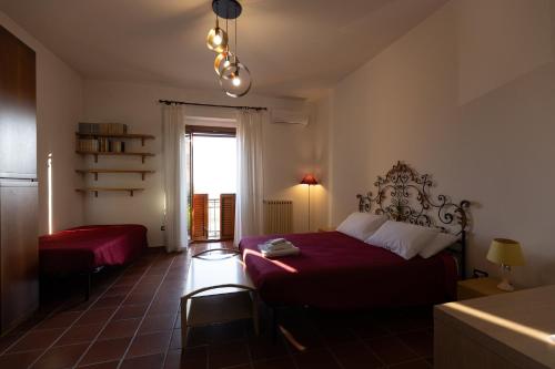 a bedroom with a red bed and a window at La Vista Colliano in Colliano