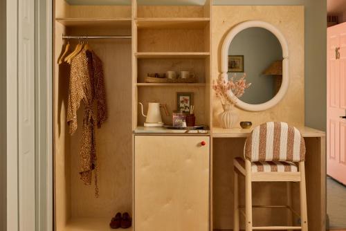 a dressing room with a refrigerator and a mirror at The June Motel, Prince Edward County in Picton