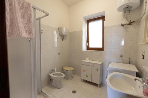 a white bathroom with a toilet and a sink at La Vista Colliano in Colliano