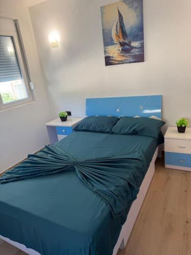 a bedroom with a bed with a blue comforter at Lux apartment in Dobra Voda