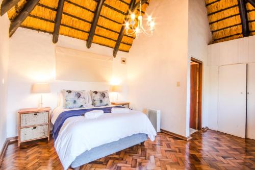 a bedroom with a bed and a wooden floor at Ambleside Cottage in Underberg