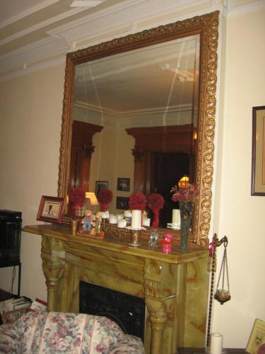 a mirror over a fireplace in a living room at Olde Judge Mansion B&B in Troy