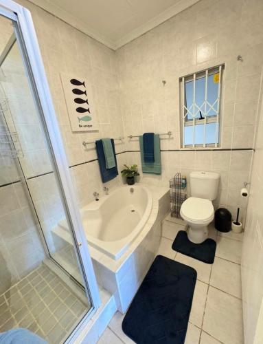 a bathroom with a tub and a toilet and a shower at Kei Sands Nr 6 in Kei-mouth Village