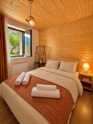 a bedroom with a large bed with two towels on it at Guest House Keti Margiani Mestia in Mestia