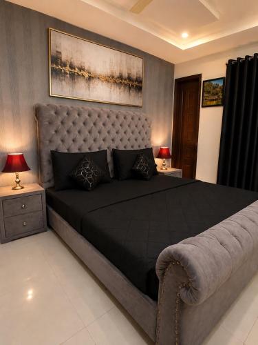 a bedroom with a large bed and two lamps at Family-Friendly Luxury Apartment Home Away From Home in Islamabad