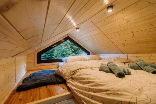 a large bed in a room with a window at Tiny House Dolinky in Veľká Lesná