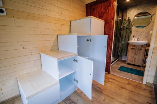 a room with a white refrigerator and a sink at Tiny House Dolinky in Veľká Lesná