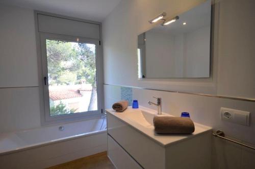 ベグールにあるCasa Es Plomのバスルーム(洗面台、鏡、窓付)