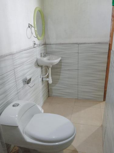 a bathroom with a toilet and a sink and a mirror at Amazon Lodge and Expeditions in Iquitos