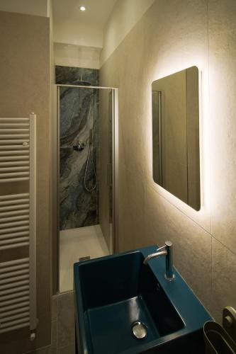 a bathroom with a blue sink and a shower at Hotel Columbia in Marina Romea