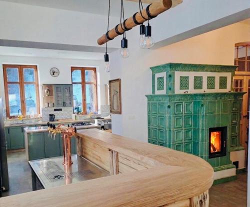a kitchen with a green stove and a fireplace at Celnice pod Sněžníkem-Nová Seninka in Staré Město