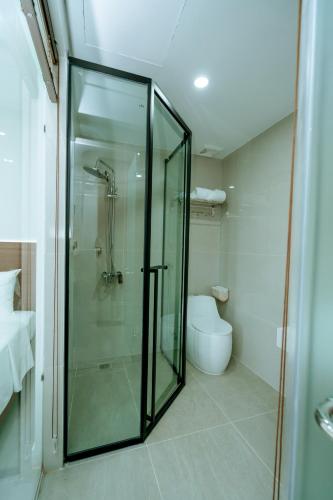 a bathroom with a glass shower and a toilet at Thành Danh Hotel in Dong Hoi