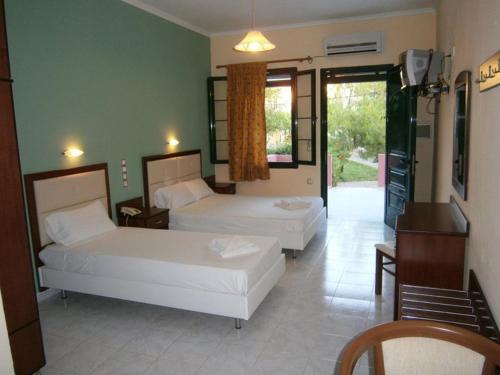 Habitación de hotel con 2 camas y balcón en Portego, en Laganas