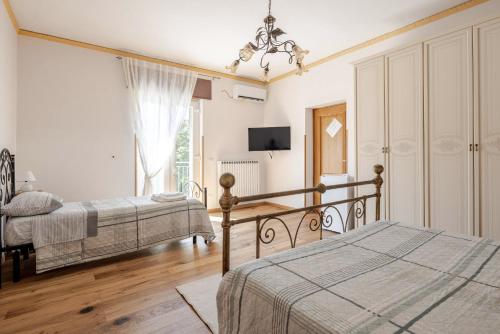 a bedroom with two beds and a chandelier at Civico4 - Osteria Varanalle in Ariano Irpino
