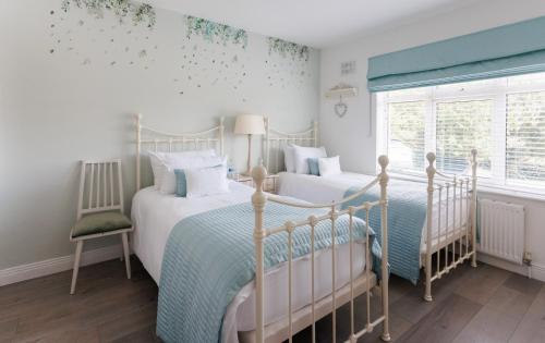 two twin beds in a bedroom with a window at Grangebeg B&B Dunlavin W91FK50 in Dún Luáin