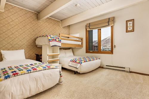 a bedroom with two bunk beds and a window at Chateau Dumont Unit 10, Centrally Located Condo, 1 Block from the Gondola in Aspen