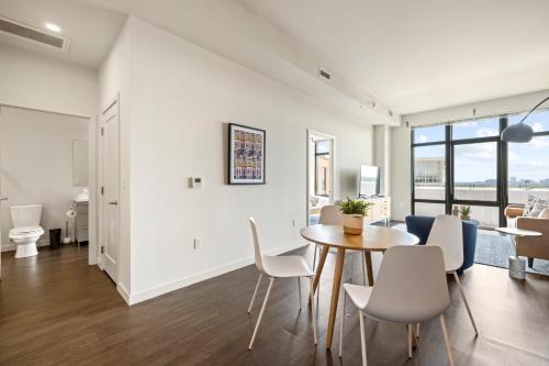 a dining room and living room with a table and chairs at Placemakr Marymount Ballston in Arlington