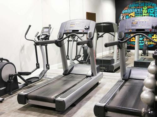a gym with three tread machines in a room at Mercure Sao Paulo Paulista in São Paulo