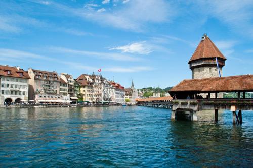 a view of a river with a bridge and buildings at Hotel Pickwick and Pub "the room with a view" in Luzern