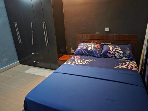 a bedroom with a blue bed and a closet at TwinVilleCove, affordable villas located in Ajah in Aja