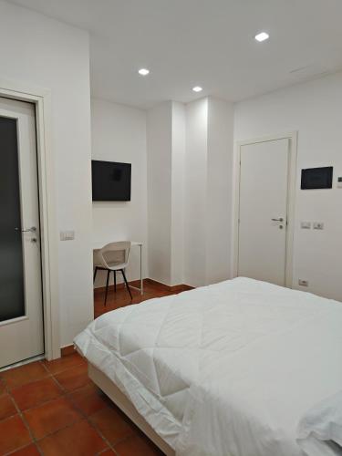 a white bedroom with a bed and a chair at Dream Rooms Palomonte 