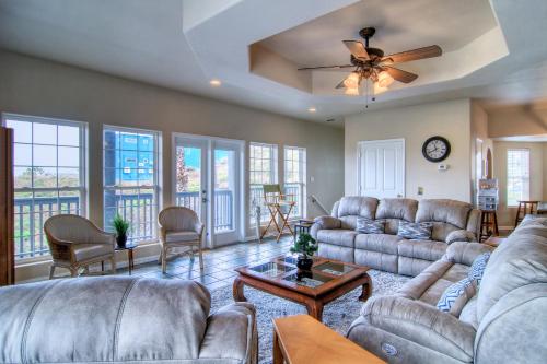 a living room with couches and a ceiling fan at Happy Heron in Port Aransas