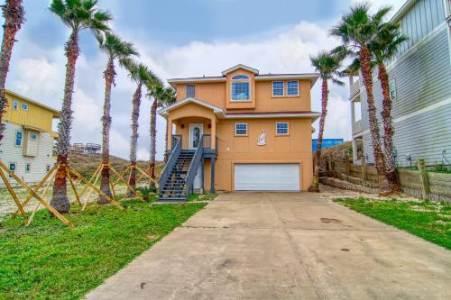a house with palm trees in front of it at Happy Heron in Port Aransas