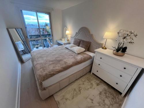 a bedroom with a bed with a dresser and a window at Superbe appart chic & élegant 2ch - 6 pers in Deuil-la-Barre