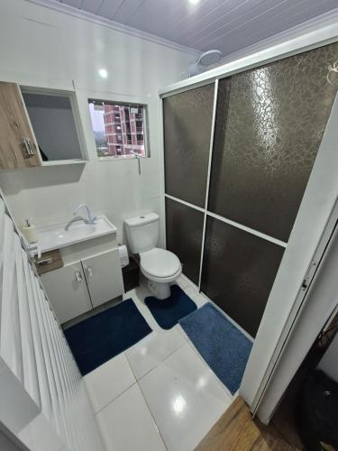 a small bathroom with a toilet and a shower at Pousada Maria in Maravilha