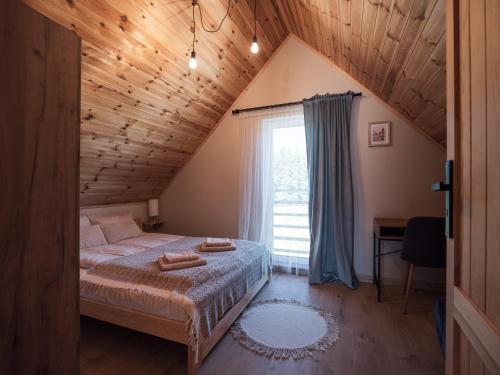 a bedroom with a bed with two towels on it at SierPlejs Hill - domki przy szlaku w Górach Sowich in Sierpnica