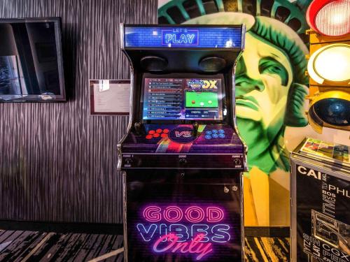 a video game machine with a joker painted on the wall at Ibis Styles Strasbourg Centre Gare in Strasbourg