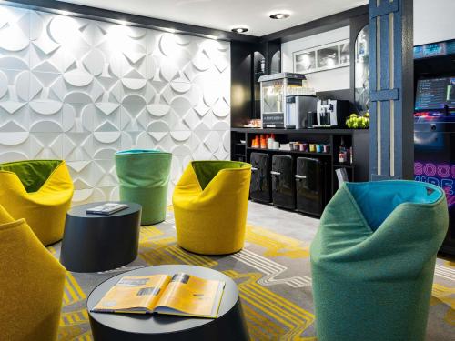 a restaurant with yellow and green chairs and a table at Ibis Styles Strasbourg Centre Gare in Strasbourg