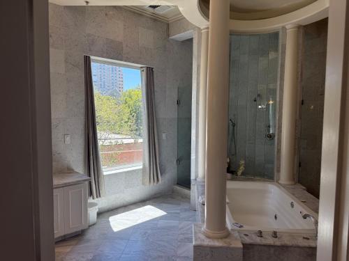 a large bathroom with a tub and a window at The Sterling Hotel in Sacramento