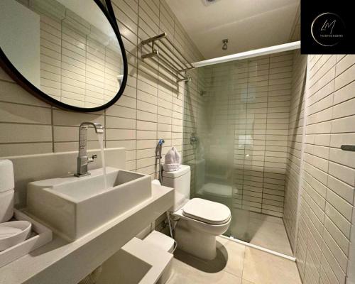 a bathroom with a sink and a toilet and a mirror at LM Infinity Cabo Branco in João Pessoa