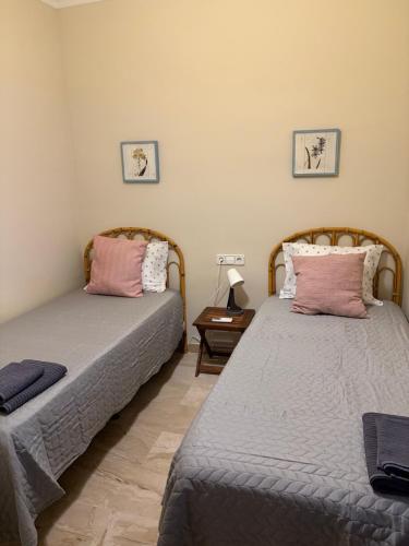 two beds sitting next to each other in a room at Ático Santa Lucía Terraza y Parking gratuitos in Alcalá de Guadaira