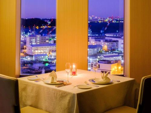 a table with a view of a city at night at Mercure Yokosuka in Yokosuka