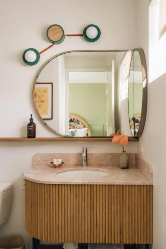 a bathroom with a sink and a mirror at Wayfinder Waikiki - Voted Top 10 Best Hotels in Hawaii! in Honolulu