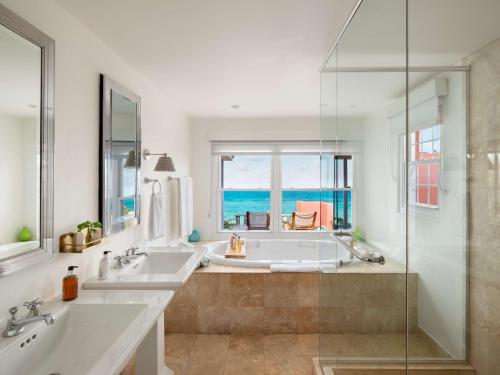 a bathroom with two sinks and a window with the ocean at Cambridge Beaches Resort and Spa in Somerset