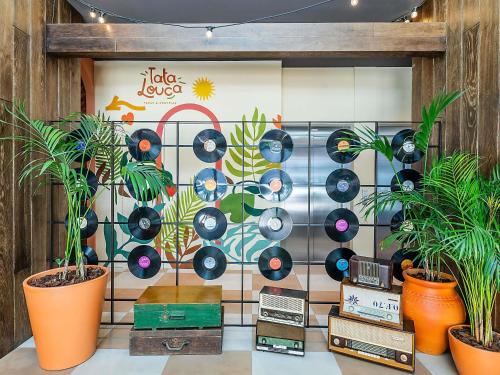 a wall with a cd mural in a room with plants at Hotel Ibis Lisboa Parque das Nações in Lisbon