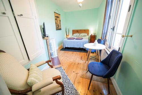 a living room with a bed and a table and chairs at Le Gîte d'Olympe in Cordes-sur-Ciel