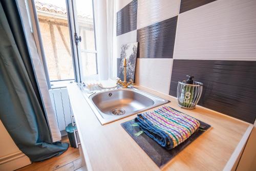 a bathroom with a sink and a window at Le Gîte d'Olympe in Cordes-sur-Ciel