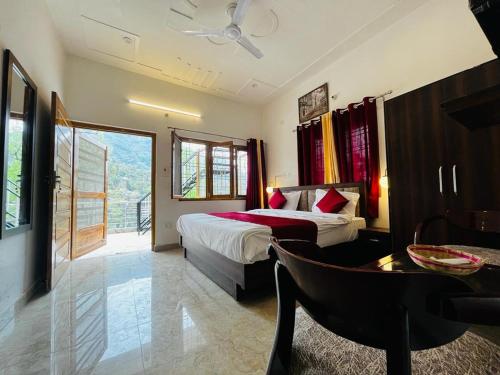a hotel room with a bed and a desk and a table at The lake house in Bhīm Tāl