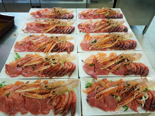 a bunch of different types of seafood on plates at Hotel Napoleon in Torre Melissa