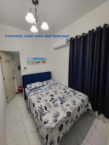 a small room with a bed and a blue curtain at Paseo Miami in Miami