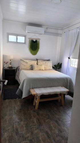 a bedroom with a bed and a bench in it at Exelente Ubicación! Oasis Urbano Apartamento Piscis in San Nicolás de los Arroyos
